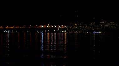 Gece şehrinin ışıkları denizin arka planında. Turizm ve seyahat, kopyalama alanı, yapı