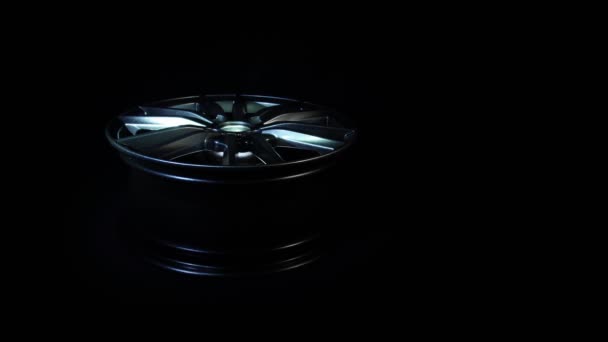 Modern steel alloy wheel for auto and vehicle. Luxury design. New aluminium or magnesium equipment for car in dark background. Expensive bright metal disk made of carbon. One-piece clean wheel lies — Stock Video