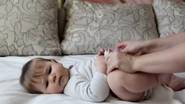 Madre viste pañal a pequeño niño caucásico, niño pequeño de 8 meses, de ojos marrones — Vídeo de stock