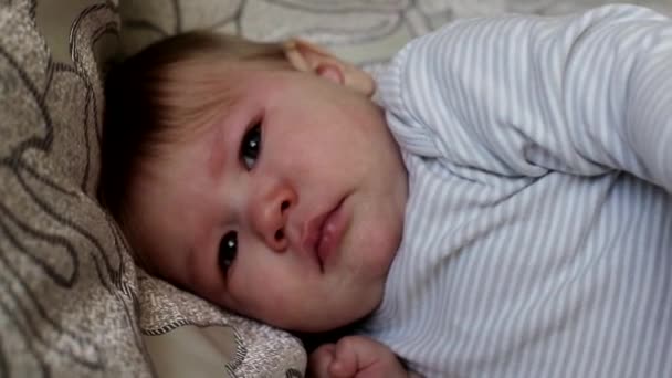 El pequeño niño caucásico se ofende y llora. Emoción del bebé en la cara, fondo — Vídeos de Stock