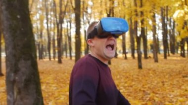 Sanal gerçeklik gözlüklü genç beyaz bir adam kaçar ve korku hisseder. Sanal gerçeklik gözlüklü bir adam sonbahar ormanında ağır çekimde koşar.