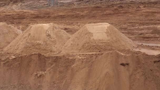 Um caminhão pesado derrama areia de um corpo em uma pedreira. Material de construção de areia. Descarregar o solo de um corpo de caminhão, fundo, indústria — Vídeo de Stock