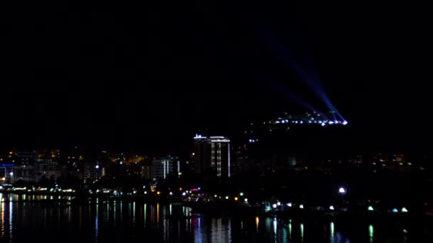 Ljus av natten staden på bakgrunden av havet. Hotell och kaféer vid havet, kopiera utrymme — Stockvideo