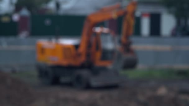 Excavator for loading sand on the background of a construction site in the rain. Blurry, copy space, industry — Stock Video