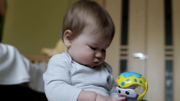 Küçük güzel erkek bebek evde oyuncaklarla oynanır. 8 aylık, beyaz bir çocuk. Büyük kahverengi gözler. — Stok video