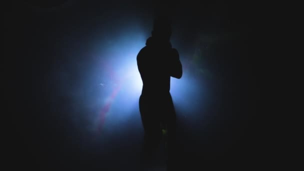 Jeune homme musclé et sexy dansant dans l'ombre sur le fond d'un projecteur — Video