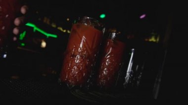 Barmen, gece kulübündeki bar taburesinin ya da taburenin üzerine bir bardak alkollü kokteyl koydu. Genç yaşam tarzı ve tatil konseptinde rahatlatıcı. Hollanda açılı el vuruşu