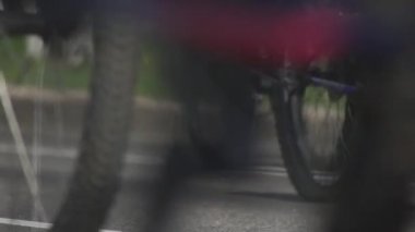 Bisiklet maratonu. Şehirde toplu bisiklet gezileri. Bisikletçiler için yarış müsabakası. Ana caddede bisikletleri olan vatandaşlar. Sporculardan oluşan bir sütun. Düşük açılı tekerler.