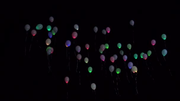 Globos multicolores vuelan en el cielo nocturno. Vacaciones y diversión concepto, fondo, espacio de copia — Vídeo de stock