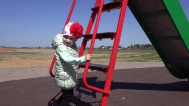 Küçük güzel beyaz kız annesiyle oyun parkında oynuyor. Güneşli bahar havası arka plan, açık hava