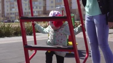 Küçük güzel beyaz kız annesiyle oyun parkında oynuyor. Güneşli bahar havası arka plan, açık hava