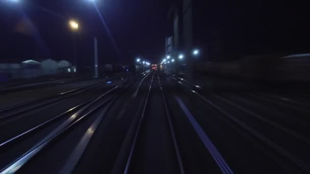 O trem ferroviário Timelapse passa através do garfo ferroviário. Vista em trilhos da janela traseira da última carruagem de ônibus à noite em movimento. Viagens e turismo conceito. Comboio de passageiros que sai da cidade — Vídeo de Stock