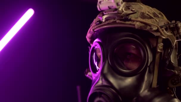 En militär soldat i modern utrustning och en gasmask håller ett gevär i sina händer. Begreppet krig i den moderna världen, långsam mo — Stockvideo