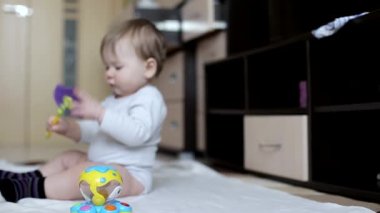 Küçük güzel erkek bebek evde oyuncaklarla oynanır. 8 aylık, beyaz bir çocuk. Büyük kahverengi gözler.