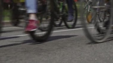 Bisiklet maratonu. Şehirde toplu bisiklet gezileri. Bisikletçiler için yarış müsabakası. Ana caddede bisikletleri olan vatandaşlar. Sporculardan oluşan bir sütun. Düşük açılı tekerler.