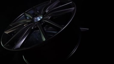 Siyah arka planda alüminyumdan yapılmış modern otomotiv alaşımı tekerleği, endüstri. Araba, tamirci, kopyalama alanı için tasarımcı moda tekerlekleri