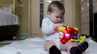 Küçük güzel erkek bebek evde oyuncaklarla oynanır. 8 aylık, beyaz bir çocuk. Büyük kahverengi gözler.