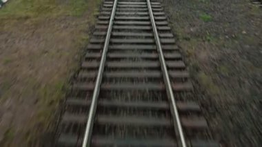 Gündüz vakti ilk demiryolu lokomotifinin ön camından hareket halindeki raylara bakın. Seyahat konsepti. Demiryolu yolcu treni yavaş gidiyor. Tren vagonu. Ulaşım. Arkaplan