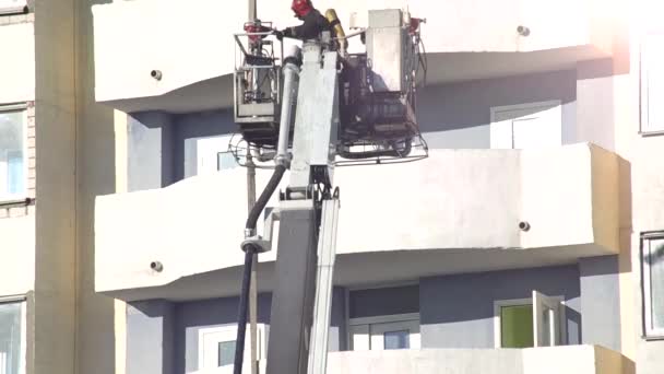 Camion antincendio piattaforma aerea solleva i vigili del fuoco in un cesto protettivo per spegnere un incendio in un grattacielo a più piani, pompiere — Video Stock