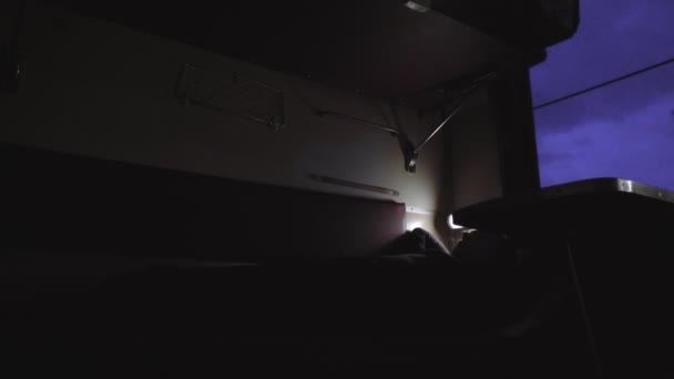 İnsan, demiryolu yolcu treninin koridor vagonunun kompartımanında yatıyor ve uyuyor. Gece giden vagon vagonu. Seyahat ve turizm konsepti. İç mekan, ulaşım. Pencere — Stok video