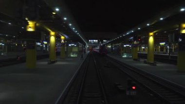 Tren yolcu tren istasyonundan gece kalkıyor. Tren vagonunun son vagonunun arka penceresinden hareket halindeki görüntüsü. Seyahat ve turizm konsepti. Tren kalkıyor.
