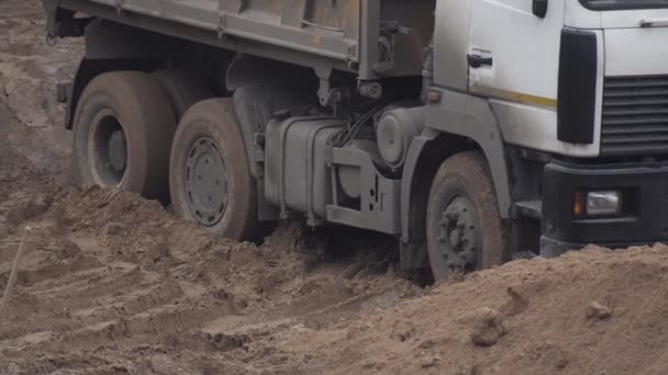 Um camião de construção parado na areia. Bloqueio diferencial central, fundo, indústria. Aperto das rodas — Vídeo de Stock