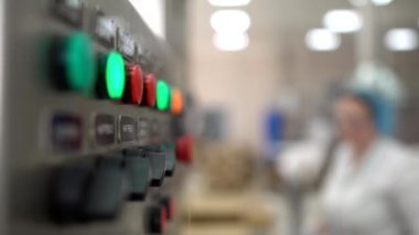 Otomatik üretim hattının kontrol paneli. Kadın işçiler fabrikada ürün paketliyor. Endüstri, kopyalama alanı
