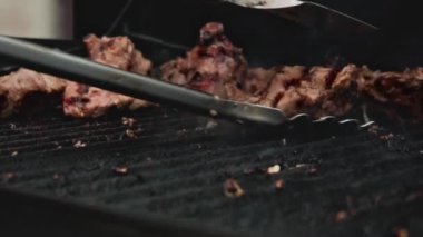 Aşçı ızgarada taze et hazırlar, üniformalı kızartma için eti çevirir. Sulu iştah açıcı et ızgara, yavaş çekim, ızgara et.