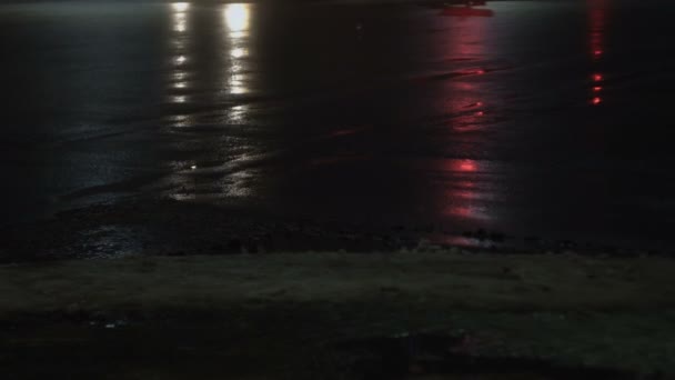 Camión pasar el cruce y avenida de la calle. Ciudad nocturna en niebla en invierno. Vista de cerca de las ruedas. Reflexión sobre el asfalto húmedo. Luz de los faros — Vídeos de Stock