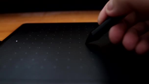 Een man tekent en werkt op een computer met behulp van een grafische tablet, close-up — Stockvideo