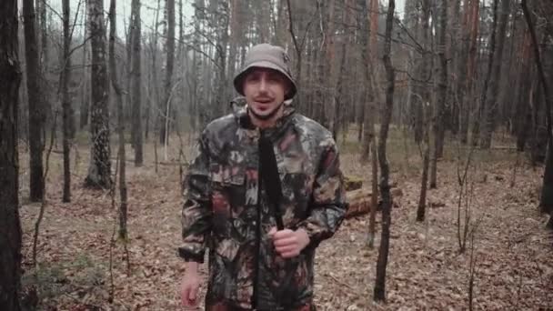 Hunter Forest Ranger klädd i en kamouflage kostym säger något till kameran. Märklig reporter med mikrofon. 30 år gammal kaukasisk man bloggare med mustasch och stubb i panama hatt — Stockvideo