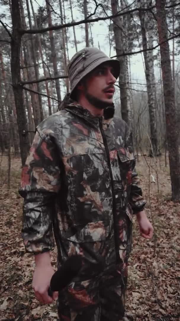 Hunter Forest Ranger i kamouflage kostym tänker på något. Vertikalt skott. Märklig reporter med mikrofon. Man bloggare med mustasch och stubb i panama hatt — Stockvideo