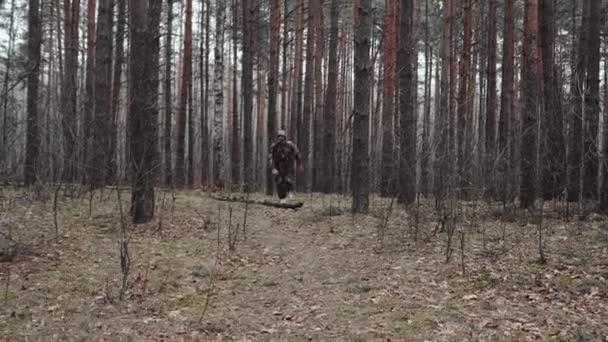 Hunter ranger vestido con traje de camuflaje corre a través del bosque. Un hombre extraño está confundido. Una situación cómica graciosa. Efecto narcótico LSD, concepto de trastorno psicológico. Persona psicodélica — Vídeos de Stock