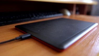 Bir adam grafiksel tablet kullanarak bilgisayarın başında çalışır ve çizer.