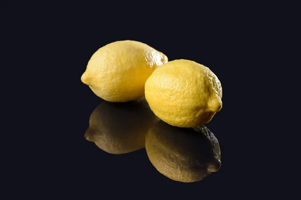 Limones sobre fondo negro espejado — Foto de Stock