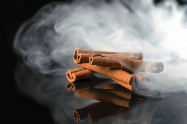 Doftande kanel rök på svart bakgrund — Stockfoto