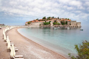 Sveti Stefan otel Adası ile ön plan boş kumsalda kasvetli hava
