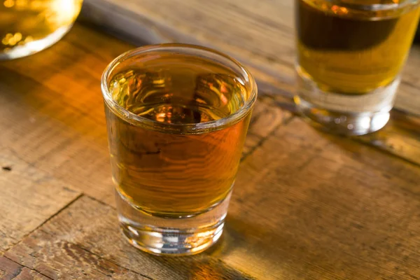 Ron marrón alcohólico en un vaso de chupito —  Fotos de Stock