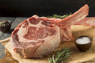 Tomahawk biftek çiğ kırmızı ot beslenen