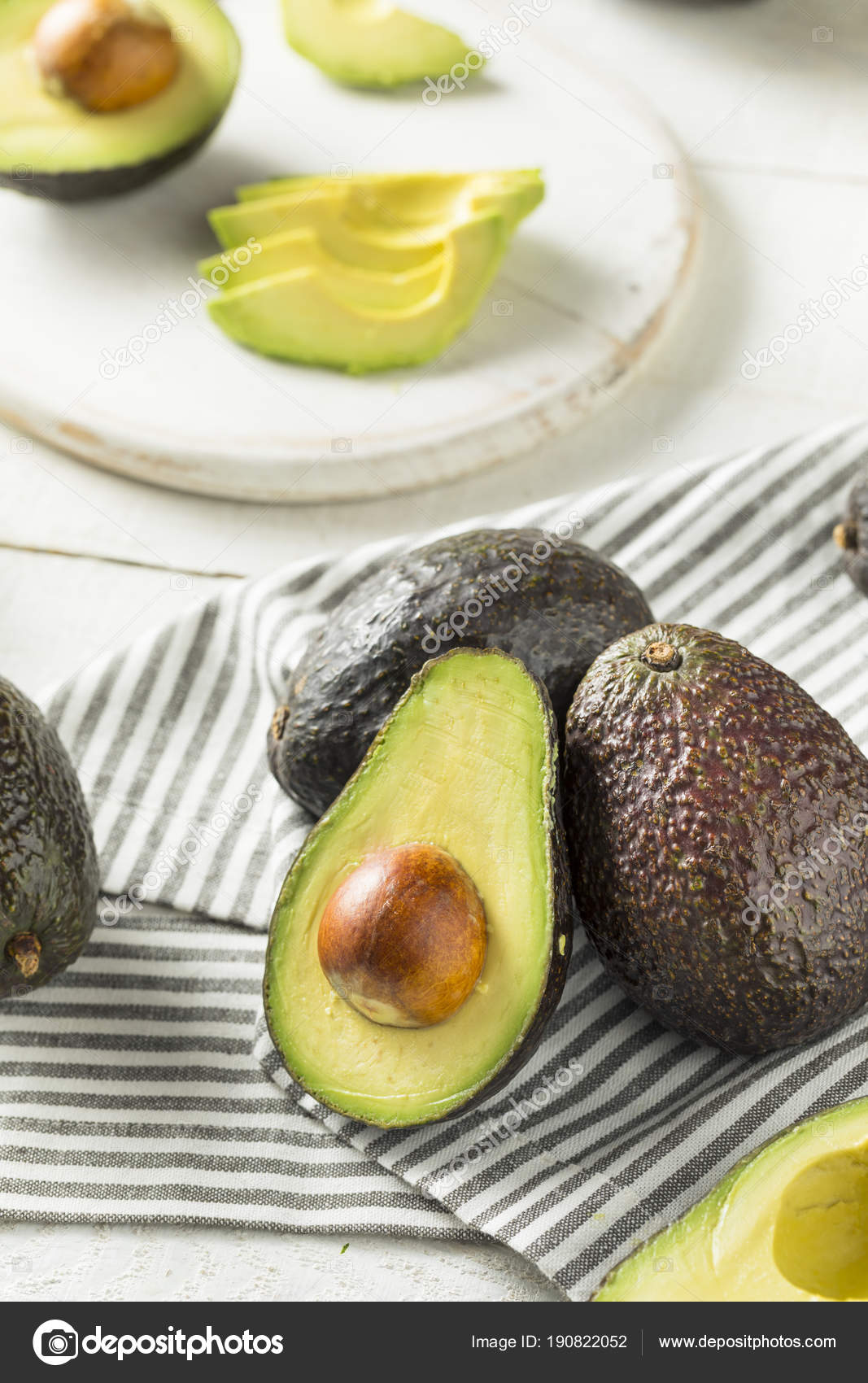 Aguacate en la tabla de corte de madera con cuchillo en una superficie