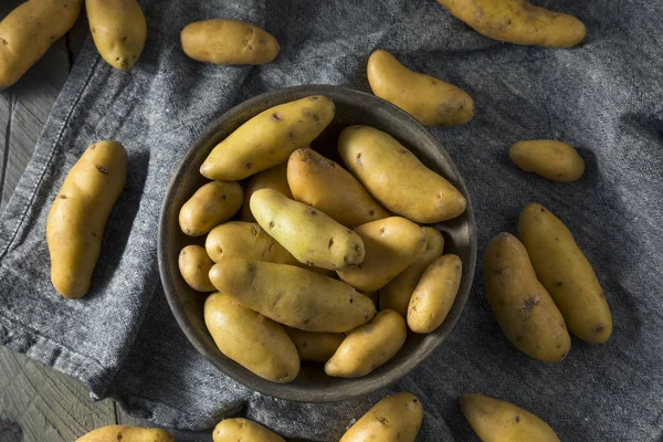 Сырая картошка с жёлтыми пальцами — стоковое фото