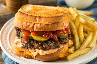 Patates ve turşulu sağlıksız peynirli hamburger.