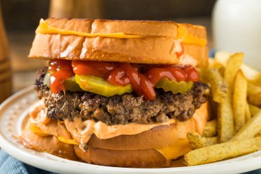 Patates ve turşulu sağlıksız peynirli hamburger.