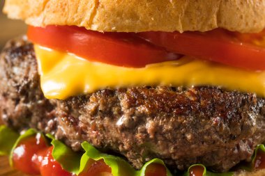 Ev yapımı Grass Fed Cheeseburger, yanında patates kızartması ve bira.