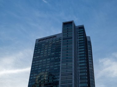 Gece karanlığında Bina Modern yüksek doğmak. Ayarlama, diğer binalar yansıtan güneş