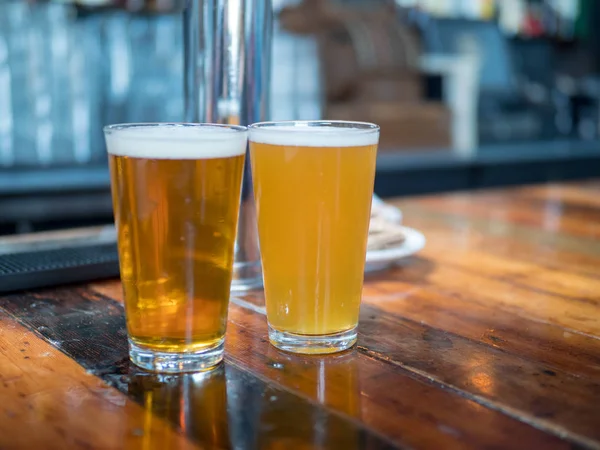 Full pint glasögon av ale och gyllene öl sitter på bardisk — Stockfoto
