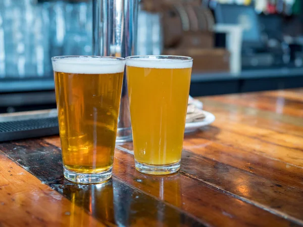 Full frostiga pint glasögon av ale och gyllene öl sitter på länder — Stockfoto