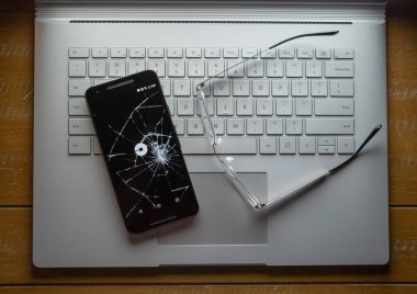 San Francisco, Ca 8 Nisan 2018: Snapchat, mesaj sosyal medya app, logo üstünde a laptop gözlük yanında oturan kırık bir cep telefonuyla yok.