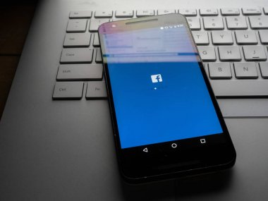 Facebook masaüstü site sc üzerinde oturan ile dizüstü bilgisayarda oturup telefon