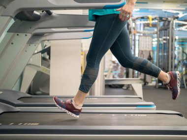 spor salonunda koşu bandı üzerinde çalışan kadın